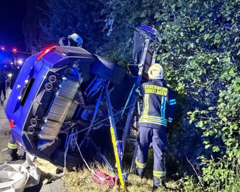 Überschlagener Pkw auf dem Dach, Feuerwehr Dinslaken sichert Unfallstelle, Ersthelfer befreien Insassen, Blaulicht.