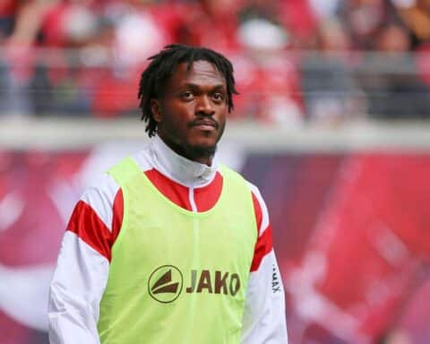 Dan-Axel Zagadou im VfB-Trikot, glücklich nach Vertragsverlängerung, Fußballplatz im Hintergrund.