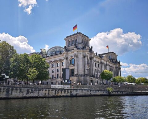 Sonniger Berliner Bundestag bei warmem Wetter, blauhimmeliger Tag mit wenigen Wolken und klarem Himmel.