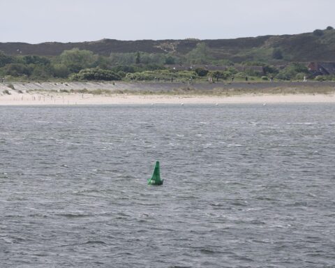 Strand und Küstenschutzanlagen bei List auf Sylt; Wolken und Sonne, freundliches Wetter.