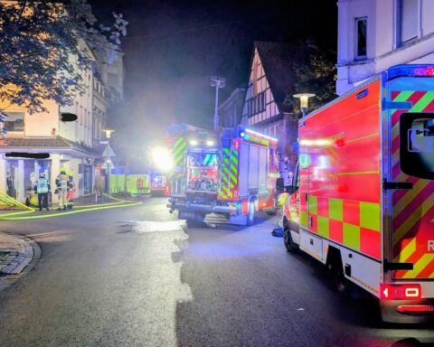 Wohnungsbrand in Kamen: Feuerwehr-Einsatz, Drehleiterrettung, Rauch aus Fenstern, Verletzte und Einsatzkräfte.
