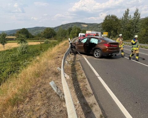 Ein BMW nach Unfall in der Leitplanke, beschädigt auf der B38 Westtangente; Feuerwehr und Unfallabsicherung.
