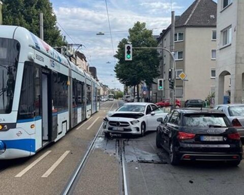 Zusammenstoß zwischen Auto und Straßenbahn, Polizei vor Ort, verletzte Personen werden behandelt.