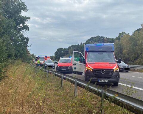 Unfall auf der A57 bei Sonsbeck: Einsatzkräfte der Feuerwehr, zwei Autos, drei Verletzte.