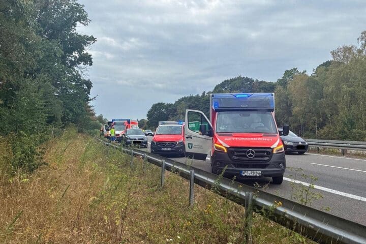 Unfall auf der A57 bei Sonsbeck: Einsatzkräfte der Feuerwehr, zwei Autos, drei Verletzte.