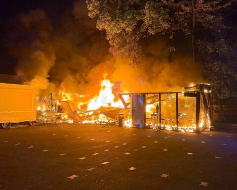 Brennender Imbissstand in Hattersheim am Main, Feuerwehr im Einsatz, flackernde Flammen am Parkplatz.