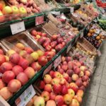 Obst im Supermarkt: Äpfel, Bananen, Erdbeeren, Orangen und Pfirsiche in der Auslage.