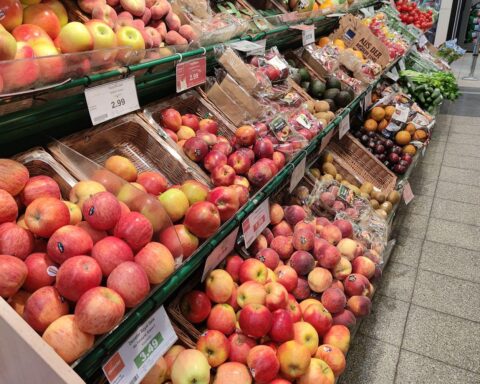 Obst im Supermarkt: Äpfel, Bananen, Erdbeeren, Orangen und Pfirsiche in der Auslage.