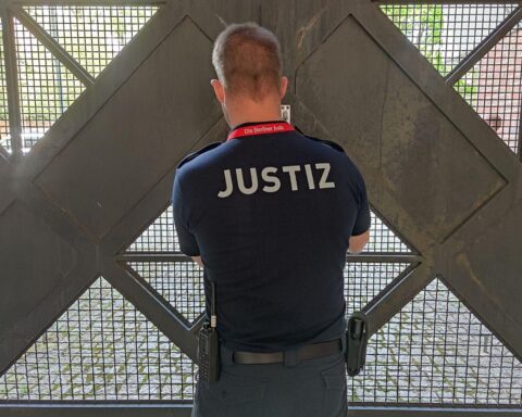 Archivfoto: Wachmeister schließt ein Gefängnistor, Hintergrund Sicherheitshaft und Terrorabwehrmaßnahmen.