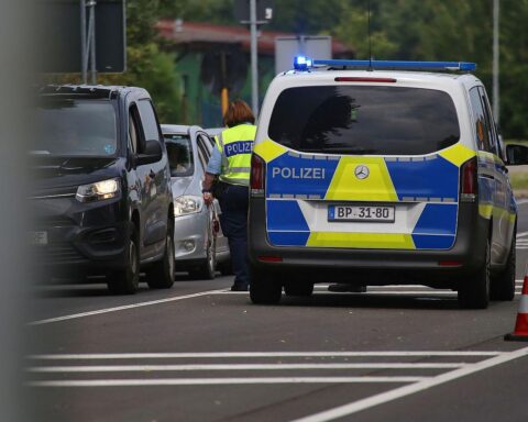 Archivfoto: Deutsche Grenzkontrolle an einer Binnengrenze; im Hintergrund Polizisten, Absperrungen und Kontrolltechnik.
