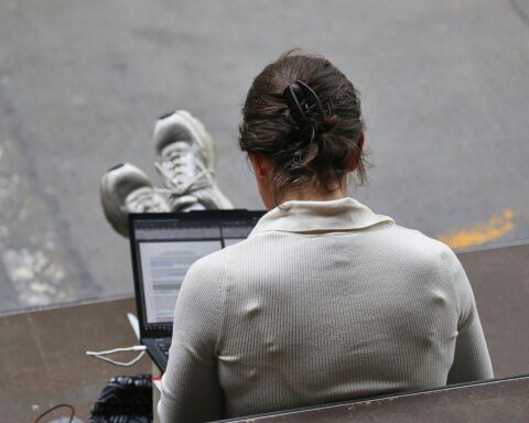 Frau mit Laptop im Archiv; Politiker warnen vor leistungsfähigen Open-Source-KI-Modellen für Cyberangriffe.