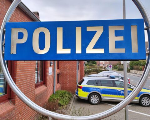 Ein Polizeifahrzeug vor einer Dienststelle (Archivfoto), im Hintergrund Gebirge: tödlicher Bergunfall im Wettersteingebirge.