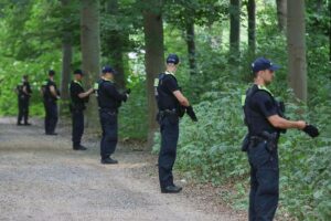 Tatort nach Todesfahrt beim CSD: Polizeiabsperrung, Gedenkkerzen und Einsatzkräfte im Zusammenhang mit Anschlag.