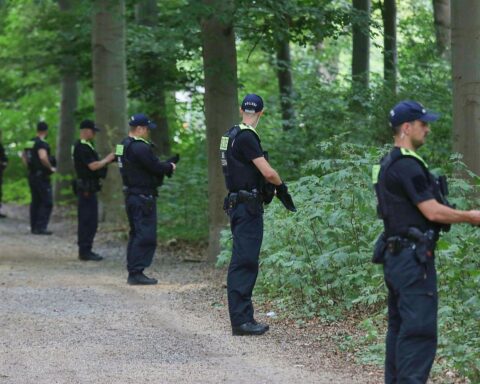 Tatort nach Todesfahrt beim CSD: Polizeiabsperrung, Gedenkkerzen und Einsatzkräfte im Zusammenhang mit Anschlag.