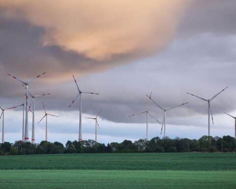 Mehrere Windräder im Archiv vor bewölktem Himmel, symbolisch für warmes, windiges Wetter in Sachsen.