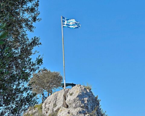 Griechische Flagge im Archiv, während in Attika westlich von Athen Waldbrände mit Hubschraubern gelöscht werden.