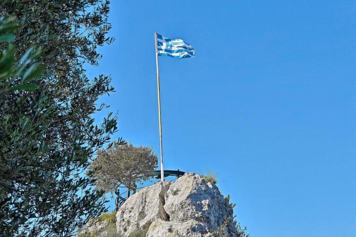 Griechische Flagge im Archiv, während in Attika westlich von Athen Waldbrände mit Hubschraubern gelöscht werden.